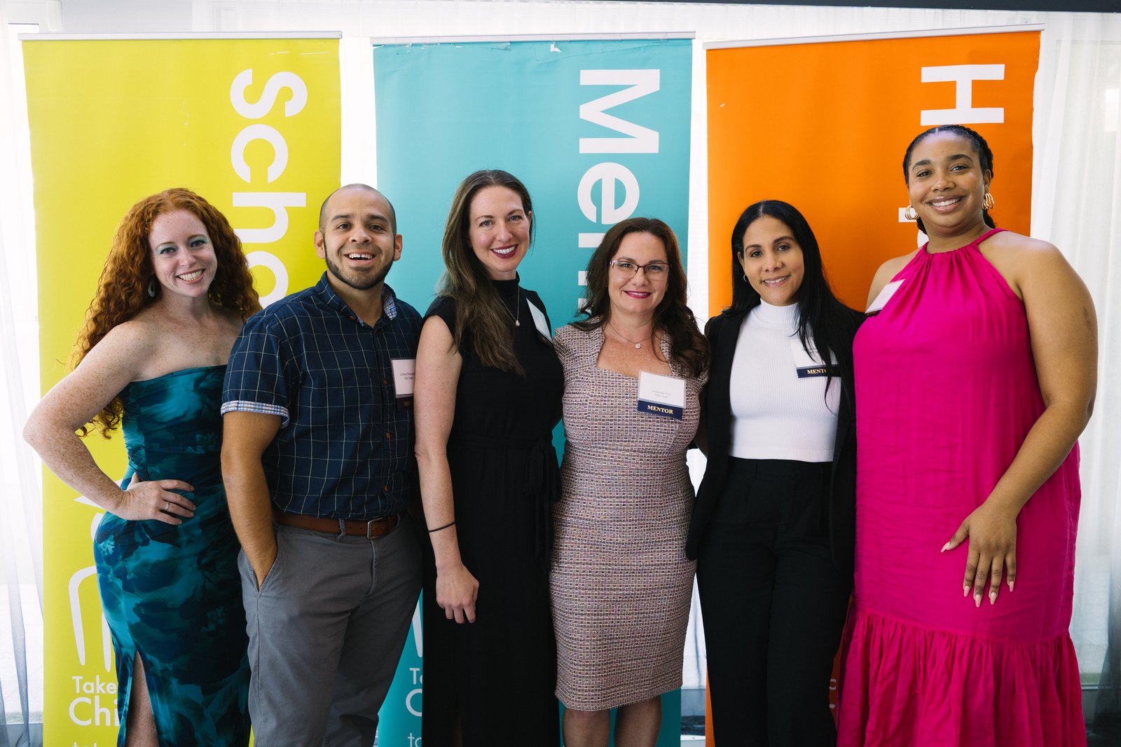 A group of supporters in front of the Scholarships, Mentors and Hope banners