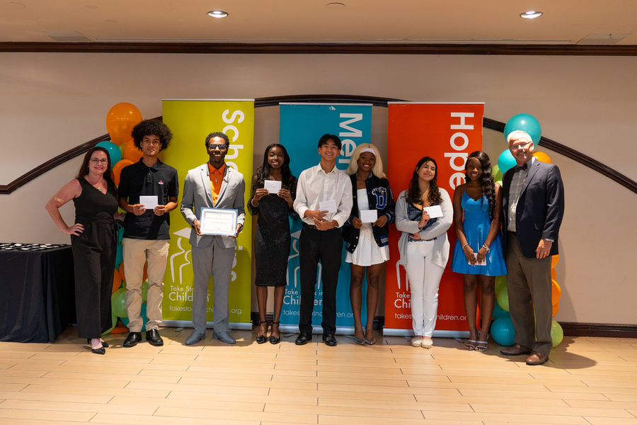 Take Stock in Children of Broward scholars at the Class of 2025 graduation ceremony, standing before the organisation's Scholarships, Mentors and Hope banners.